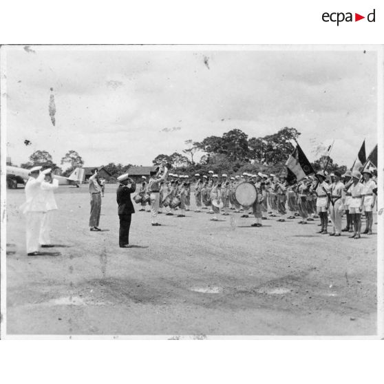 Norodom Sihanouk, roi du Cambodge, à son arrivée à l'aéroport de Tan Son Nhut salue le drapeau.