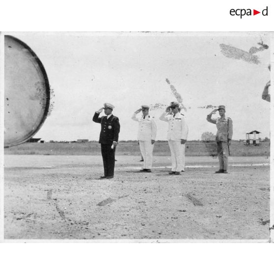 Norodom Sihanouk, roi du Cambodge, à son arrivée à l'aéroport de Tan Son Nhut salue le drapeau.