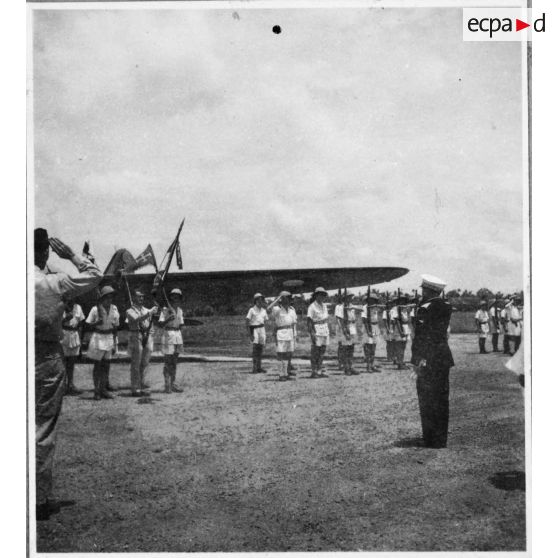 Norodom Sihanouk, roi du Cambodge, à son arrivée à l'aéroport de Tan Son Nhut salue le drapeau.