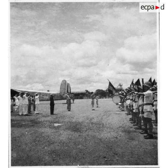 Norodom Sihanouk, roi du Cambodge, à son arrivée à l'aéroport de Tan Son Nhut salue le drapeau.