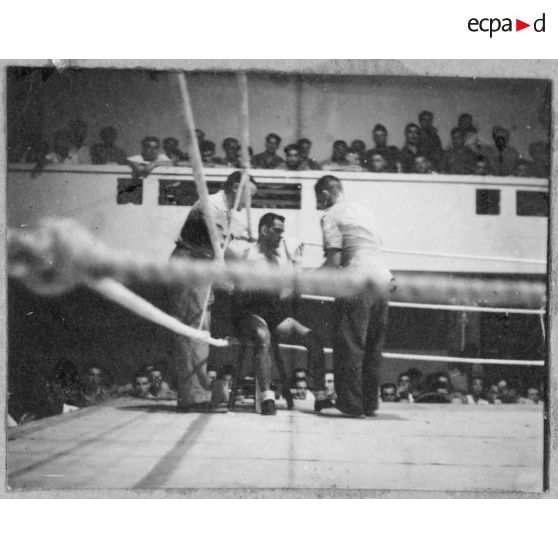 Boxeur assis au coin du ring lors d'un gala de boxe.