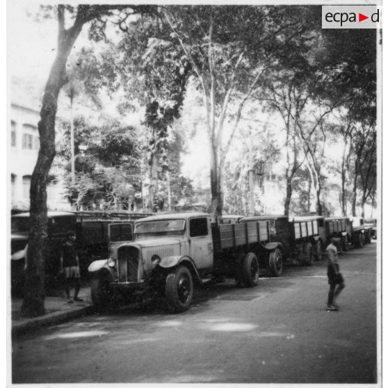 Plusieurs types de camions de modèles circulant dans les rues de Saigon.