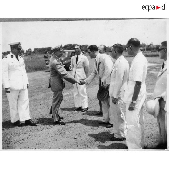 A son arrivée à l'aéroport de Bien Hoa, l'amiral Thierry d'Argenlieu  salue les représentants de l'autorité civile et militaire venues l'accueillir. [description provisoire]