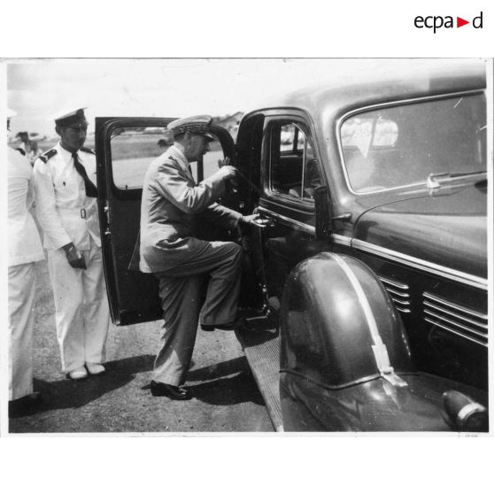 A son arrivée à l'aéroport de Bien Hoa, l'amiral Thierry d'Argenlieu monte à l'arrière d'une voiture en direction de Saigon. Il est accompagné par Jean Cédile. [description provisoire]