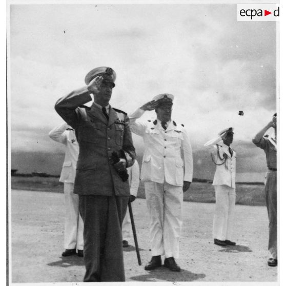 A son arrivée à l'aéroport de Bien Hoa, l'amiral Thierry d'Argenlieu passe en revue et salue les troupes en présence. [description provisoire]