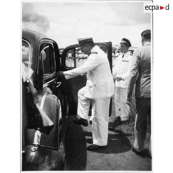 A son arrivée à l'aéroport de Bien Hoa, l'amiral Thierry d'Argenlieu monte à l'arrière d'une voiture en direction de Saigon. Il est accompagné par Jean Cédile. [description provisoire]