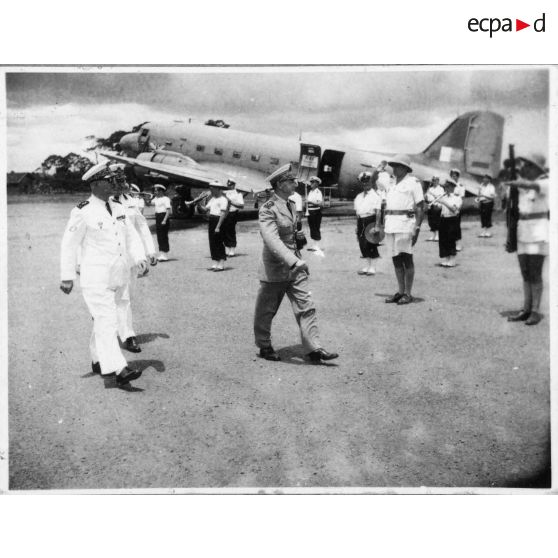 A son arrivée à l'aéroport de Bien Hoa, l'amiral Thierry d'Argenlieu passe en revue et salue les troupes en présence. [description provisoire]