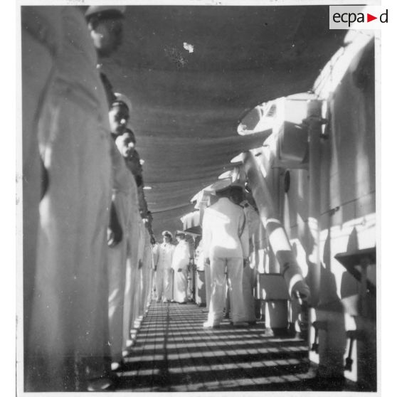 Dans le port de Saigon, lors d'une visite aux avisos "Le Chevreuil" et "La Gazelle" et à la frégate "Le Tonkinois" , l'amiral Thierry d'Argenlieu passe en revue les hommes d'équipage. [description provisoire]