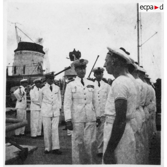 Dans le port de Saigon, lors d'une visite aux avisos "Le Chevreuil" et "La Gazelle" et à la frégate                  "Le Tonkinois", l'amiral Thierry d'Argenlieu passe en revue les troupes embarquées sur l'un des bâtiments. [description provisoire]