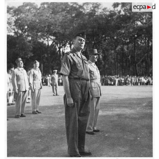 Le général Jean-Etienne Valluy se tient au garde-à-vous, probablement lors de la cérémonie du 14 juillet 1946 à Saigon. [description provisoire]