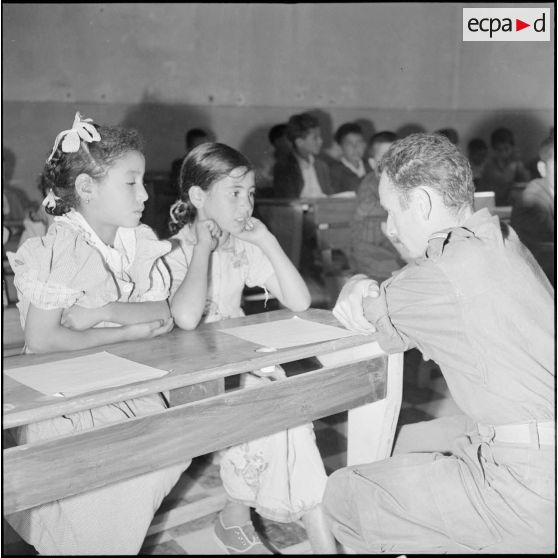 Instituteur militaire interrogeant deux fillettes algériennes lors d'une classe à Oued-El-Bahri.