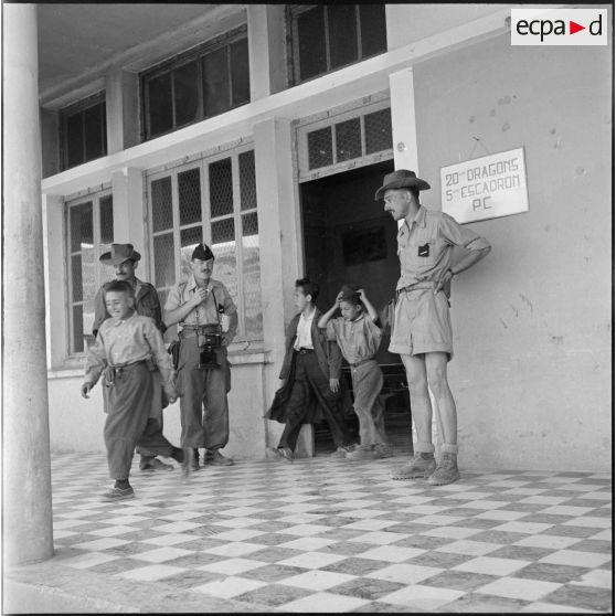 Sortie des élèves algériens de l'école d'Oued-El-Bahri pour la récréation sous la surveillance de l'instituteur militaire.