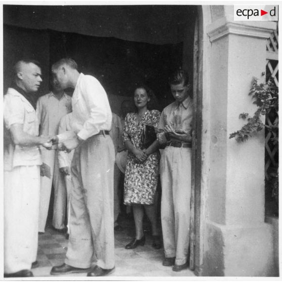 Lors du vernissage du concours des élèves de l'école d'arts appliqués de Gia Dinh, l'un des administrateurs de l'école pose devant l'entrée avec plusieurs personnes. [description provisoire]