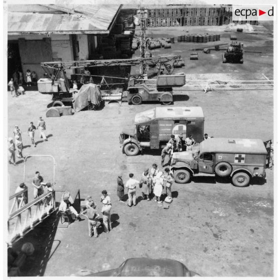 Dans le port de Saigon, les blessés sont embarqués à bord du paquebot-hôpital "Cap Saint-Jacques" en partance pour la France. [description provisoire]