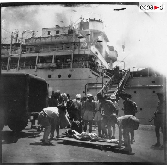 Dans le port de Saigon, les blessés sont embarqués à bord du paquebot-hôpital "Cap Saint-Jacques" en partance pour la France. [description provisoire]