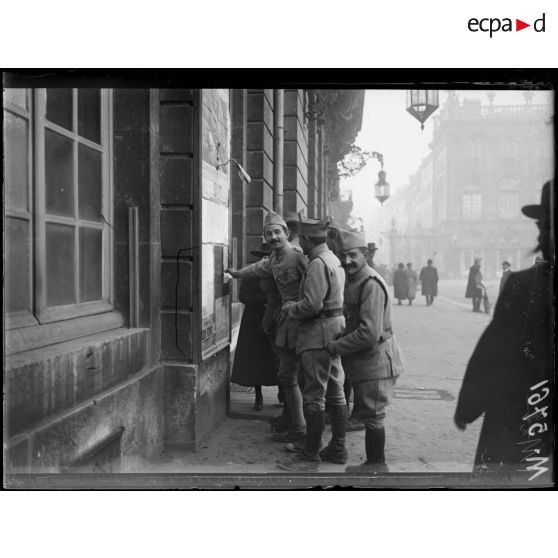 Nancy, soldats lisant les affiches qui annoncent l'Armistice. [légende d'origine]