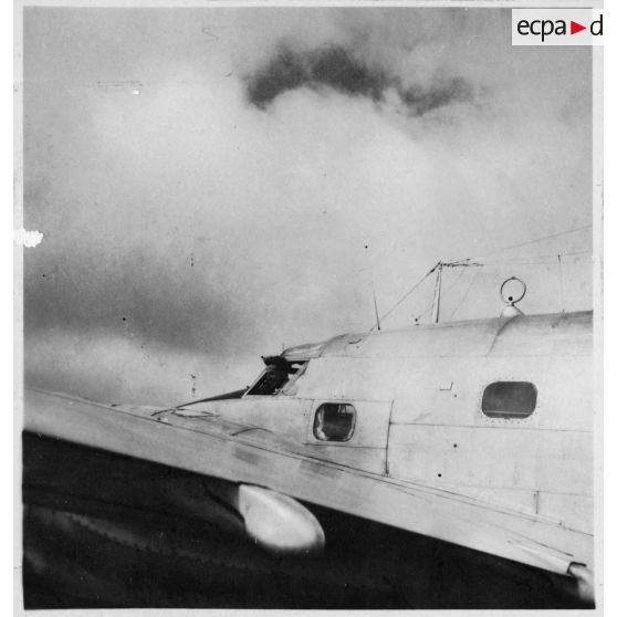 A l'aéroport de Tan Son Nhut, lors d'une remise de décorations aux fanions des compagnies du groupement aéronavale, un pilote pose à bord de son appareil, un avion de transport de type Lokheed Electra. [description provisoire]