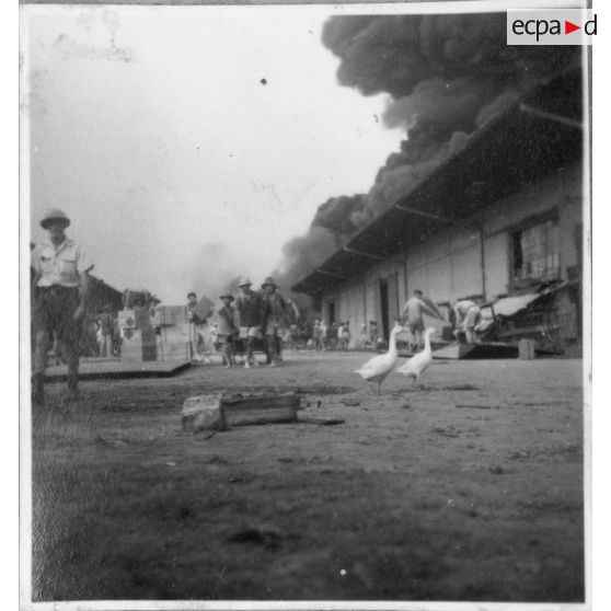 A Khanh Hoi, une commune dans les environs du port de Saigon, des hommes tentent de sauver les marchandises de l'incendie déclenché par le Viet Minh, qui ravage les entrepôts. [description provisoire]