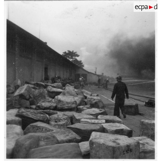 A Khanh Hoi, une commune dans les environs du port de Saigon, des hommes tentent de sauver les marchandises de l'incendie déclenché par le Viet Minh, qui ravage les entrepôts. [description provisoire]