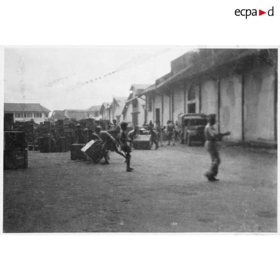 A Khanh Hoi, une commune dans les environs du port de Saigon, des hommes tentent de sauver les marchandises de l'incendie déclenché par le Viet Minh, qui ravage les entrepôts. [description provisoire]