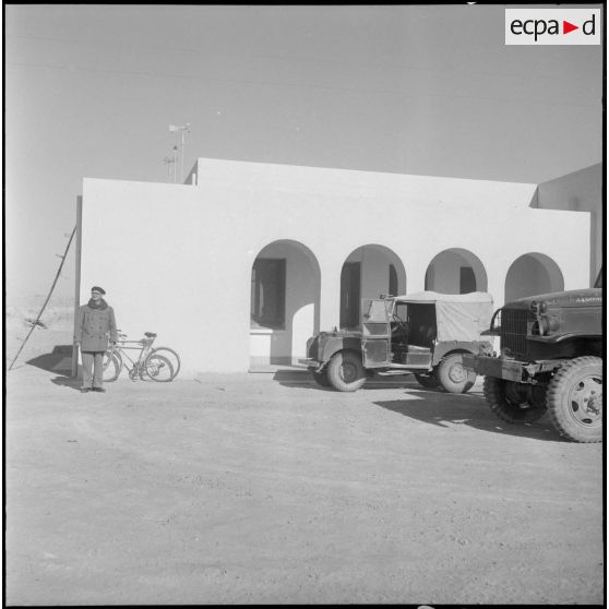 Une cour où sont stationnés une Land-Rover et un Dodge.