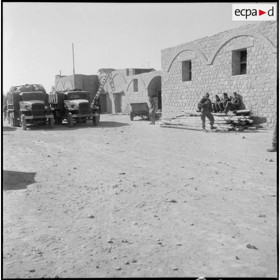 Une cour où sont stationnés deux GMC (General Motors Company).