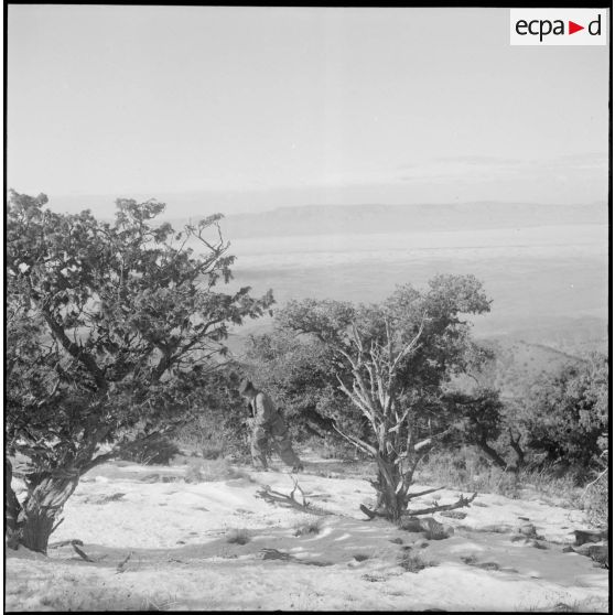 Un militaire français progresse au milieu d'un terrain désertique.