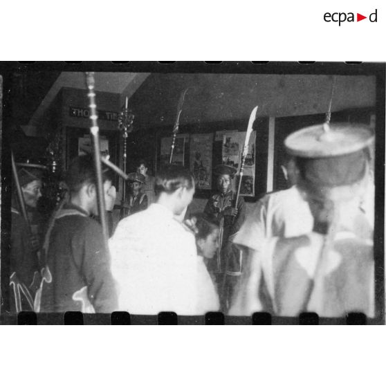 Lors d'une visite officielle de la ville de Thu Dau Mot, pour se rendre sur le lieu d'une réunion, l'amiral Thierry d'Argenlieu traverse le hall d'information de la ville. [description provisoire]