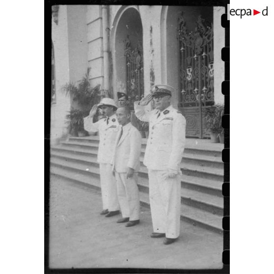 Le jour d'une conférence donnée à l'Hôtel de Ville de Saigon, le président Thinh, Mr. Torel, et un troisième représentant de l'autorité civile, se tiennent à l'entrée du bâtiment. [description provisoire]