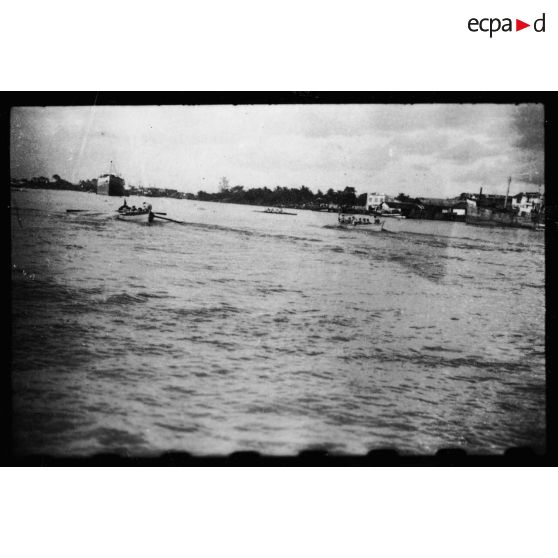 Dans le port de Saigon, plusieurs équipes s'affrontent au cours de régates.<br> [description provisoire]