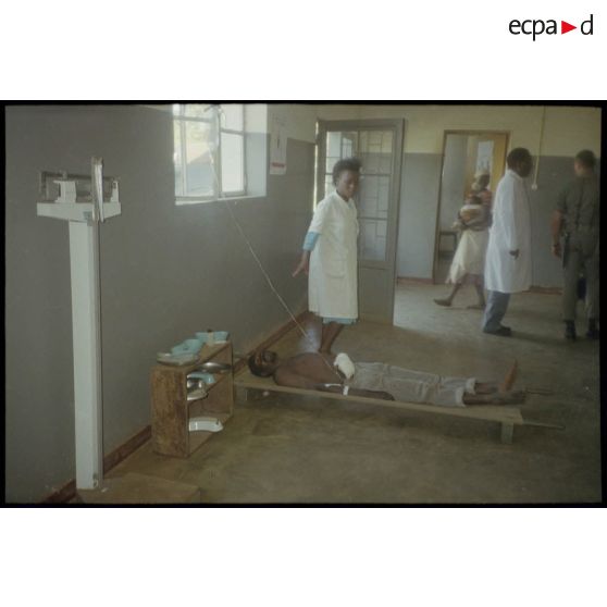 Intervention et opération chirurgicale sur un patient blessé à la main dans un dispensaire à Karama par les membres de l'antenne chirurgicale parachutiste (ACP).