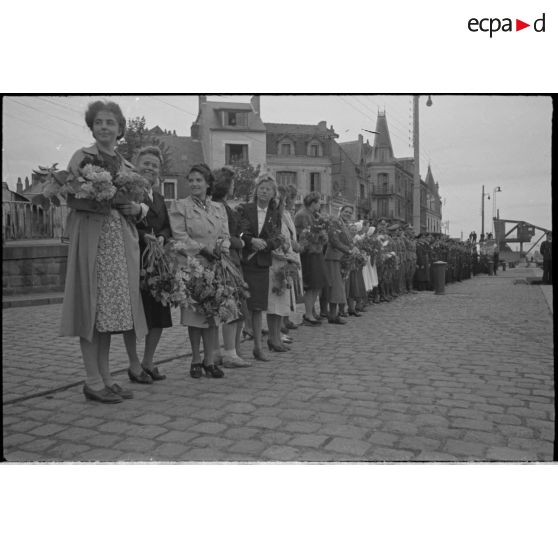 Sur le quai du port de Saint-Nazaire, des femmes alignées à côté de militaires allemands attendent le retour du sous-marin U-552.
