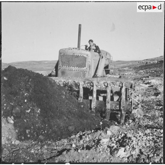 Chantiers de la Défense et Restauration des sols (DRS). Un engin Caterpillar ramène de la terre.