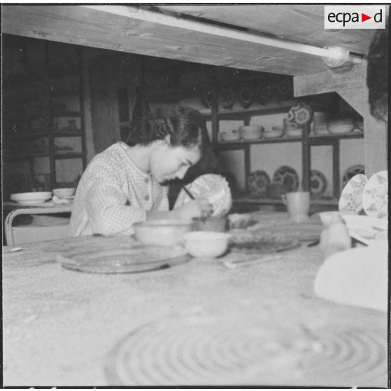 Rio Salado. Atelier de céramique. Une élève décore un plat en dessinant un arbre de la vie.