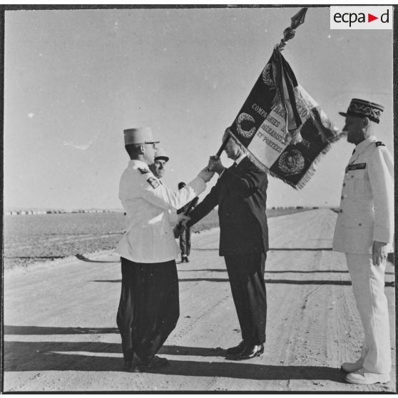 Ouargla. Pierre Messmer participe à l'échange d'étendard entre les compagnies méharistes de Mariksène et de Tinghert.