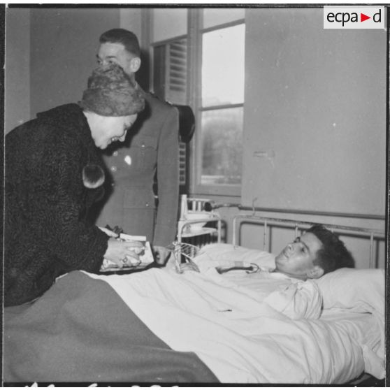 Alger. Arbre de Noël à l'hôpital Maillot. Remise de cadeaux à un grand blessé par madame  Ailleret.