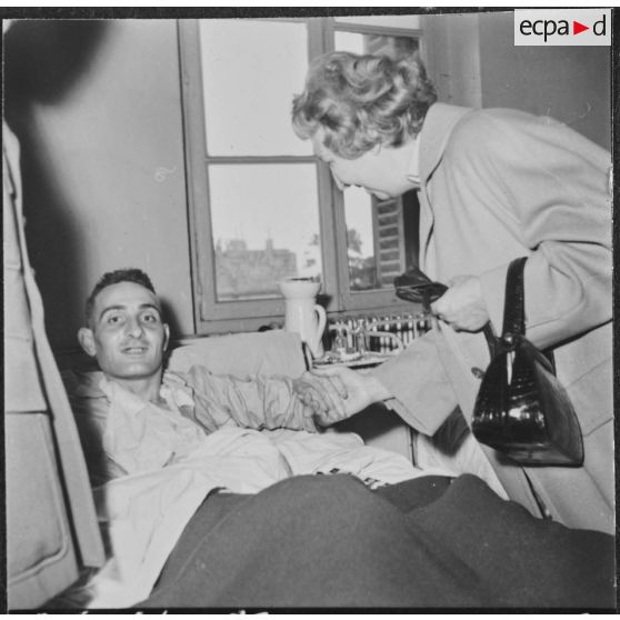 Alger. Arbre de Noël à l'hôpital Maillot. Remise de cadeaux à un grand blessé par madame de Menditte.