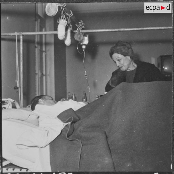 Alger. Arbre de Noël à l'hôpital Maillot. Remise de cadeaux à un grand blessé par madame  Ailleret.