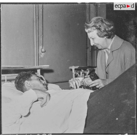 Alger. Arbre de Noël à l'hôpital Maillot. Remise de cadeaux à un grand blessé par madame de Menditte.