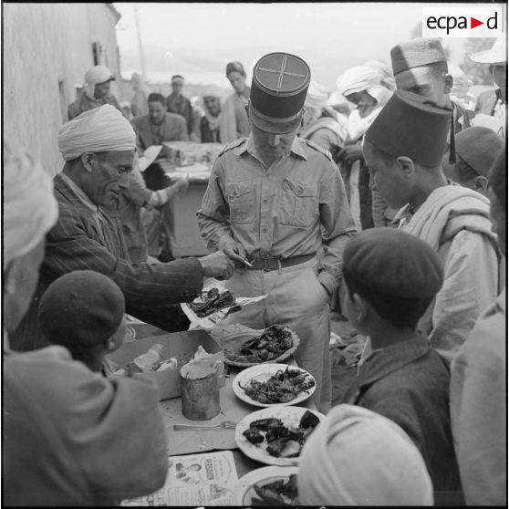 Distribution de viande auprès de la population au marché d'Ouled-El-Bahri organisée par l'officier de la section administrative spécialisée (SAS) du village.