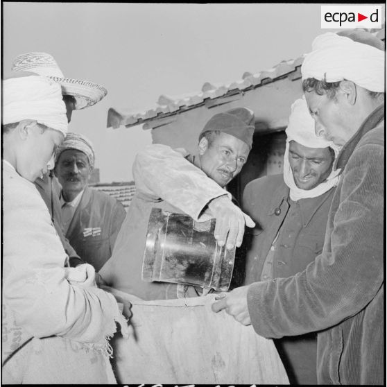 Distribution de semoule organisé par l'officier de la Section administrative spécialisée (SAS) au marché d'Ouled-El-Bahri.