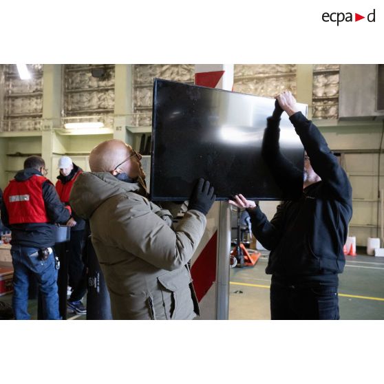Des techniciens audiovisuels installent leur matériel à bord du porte-hélicoptèress amphibie (PHA) Tonnerre à Sète.