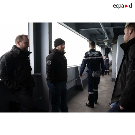 Les opérateurs vidéos Simon, Quentin et Morgan de l'ECPAD disctutent sur l'entrepont du porte-hélicoptèress amphibie (PHA) Tonnerre à Sète.