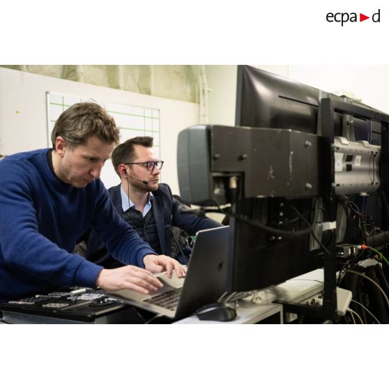 Le réalisateur-en-chef Maxence de l'ECPAD travaille avec des techniciens audiovisuels à bord du porte-hélicoptèress amphibie (PHA) Tonnerre à Sète.