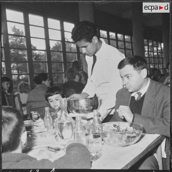 Ben-Aknoun. Ecole hôtelière. Un élève serveur sert une famille.