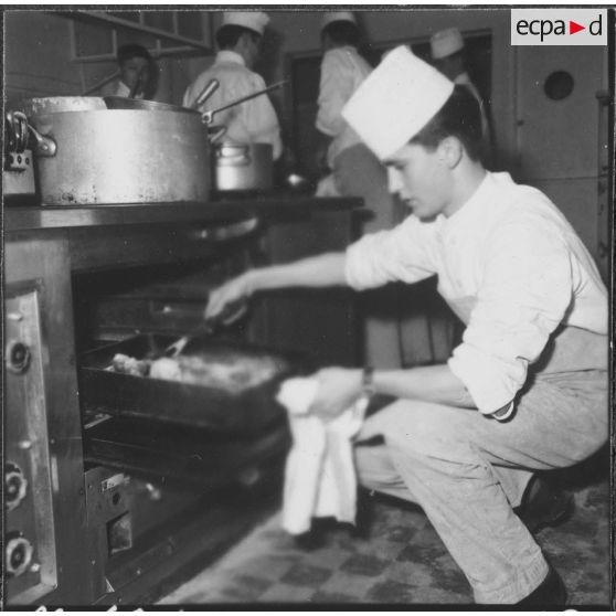 Ben-Aknoun. Ecole hôtelière. Le poulet est à point, le futur cuisinier le surveille d'un oeil attentif.