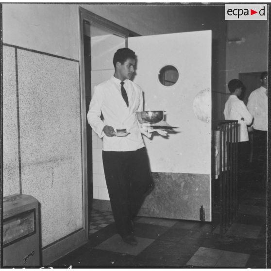 Ben-Aknoun. Ecole hôtelière. L'élève serveur sert des tables.