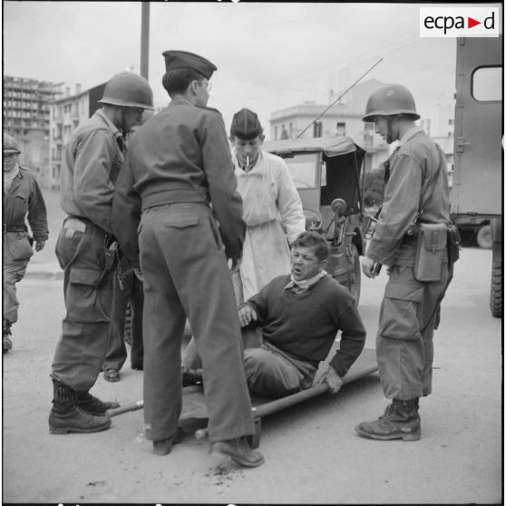 Bab el Oued. Fusillade sur le 2e bataillon du 73e régiment d'infanterie de marine (RIMa). Un gendarme blessé est amené dans un camion sanitaire.