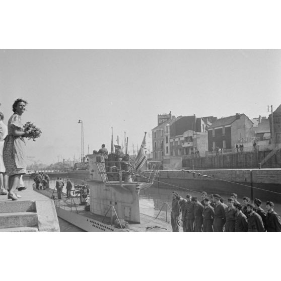 A Saint-Nazaire, une femme réserve un bouquet aux hommes du U-552 de retour de la 5e croisière du sous-marin commandé par le lieutenant (Oberleutnant zur See) Erich Topp.