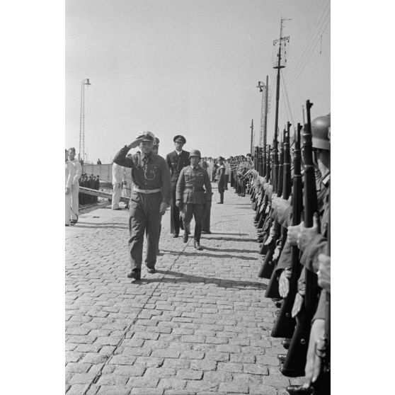 A l'issue de sa 5e mission en mer à bord du sous-marin U-552, le lieutenant (Oberleutnant zur See) Erich Topp passe en revue des autorités de la Kriegsmarine rassemblées sur le quai du port de Saint-Nazaire.
